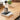 White Acaia Pearl Coffee Scale on a wooden counter with coffee beans being measured above it