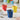 Blue Bialetti Bicchierini espresso cup filled with coffee, with colourful cups in the background
