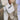 Close-up of a person carrying a cream canvas tote bag with bold “AFRICAN” text while walking along a city sidewalk