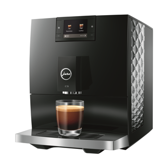 Jura C9 automatic coffee machine front view with single espresso in glass cup and touchscreen display showing drink options