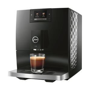 Jura C9 automatic coffee machine front view with single espresso in glass cup and touchscreen display showing drink options