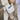 Close-up of a person carrying a cream canvas tote bag with bold “AFRICAN” text while walking along a city sidewalk