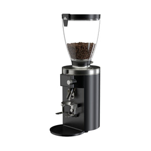 Angled view of the black Mahlkönig E65S grinder with a transparent hopper filled with coffee beans and adjustable portafilter holder.